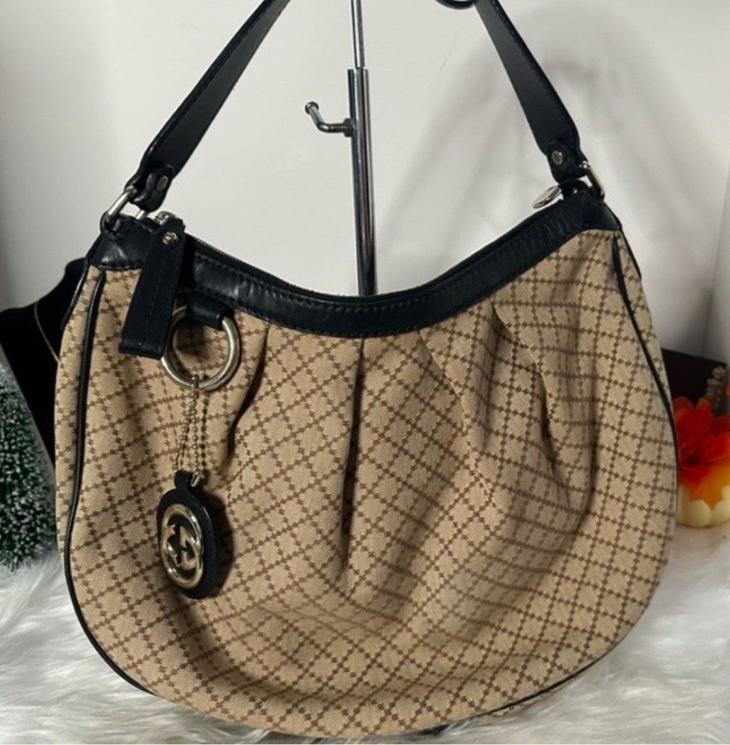 Gucci Diamante Hobo Bag (Category: Luxury Bags & Wallets) located in Aguilar. Submitted by rica040104 (Listing ID 1455555042, Image 1). Description: - Authentic Gucci hobo bag - Beige canvas with signature diamante pattern - Black leather trim and strap - Iconic Gucci GG charm detail - Interior 'Made in Italy' leather tag with serial number - Great everyday bag.