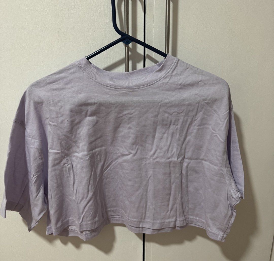 H&M Purple Cropped T-shirt (Category: Shirts) located in Muntinlupa City. Submitted by sunwonx (Listing ID 1455607637, Image 1). Description: - Light purple cropped t-shirt - Relaxed fit with short sleeves - Classic crew neck - Comfortable and casual design - Ideal for everyday wear - Easily pairs with jeans or shorts.