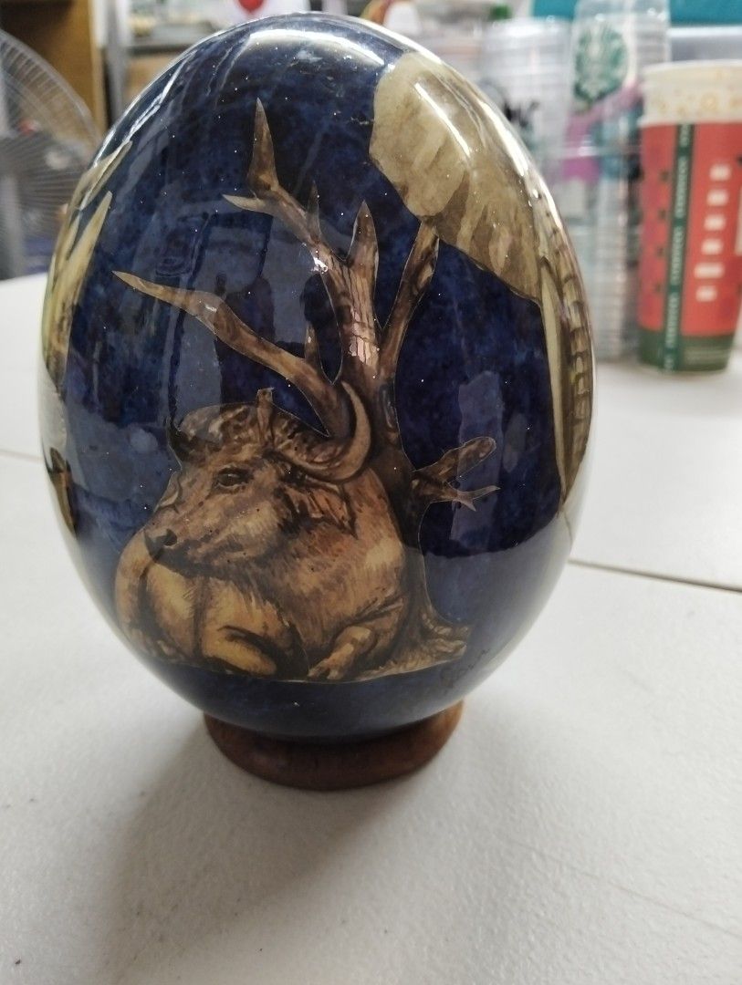 Ostrich Egg Art Display with African Animals (Category: Other Home Decor) located in Manila. Submitted by raymundm36884 (Listing ID 1455657327, Image 2). Description: - Exquisite ostrich egg with detailed African wildlife paintings (elephants, lions, leopards, rhinos, buffalo). - Includes a sturdy wooden stand for display. - Features a hole at the bottom. - Ideal for collectors or as a unique home decor statement piece..