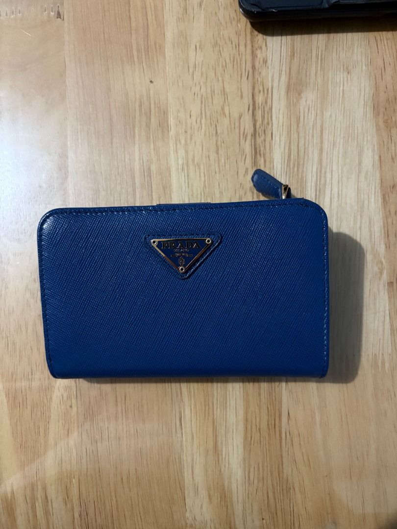 Prada Blue Saffiano Leather Wallet (Category: Luxury Bags & Wallets) located in Muntinlupa City. Submitted by rnastor (Listing ID 1455632013, Image 1). Description: Authentic blue Prada Saffiano leather wallet with card only Features card slots, zip pocket, and snap closure. Meet up can be arranged at Alabang Town Ctr or Bacoor Colisuem .