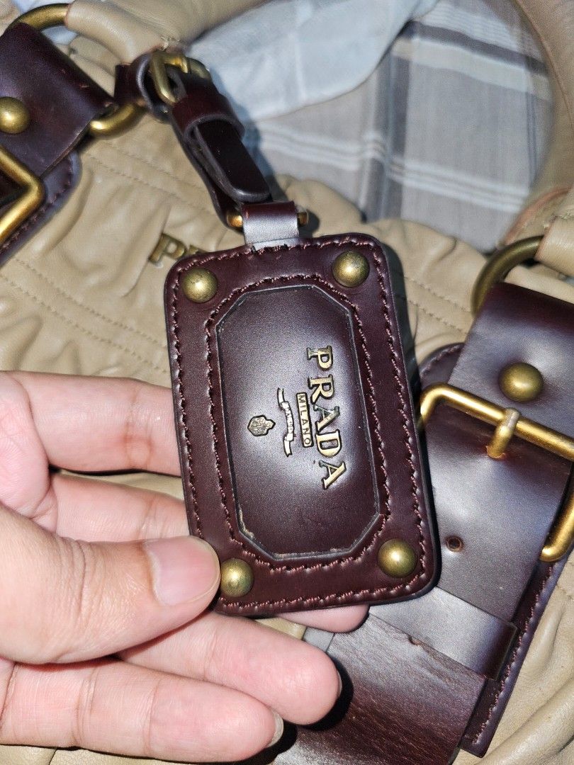 Prada Leather Handbag (Category: Luxury Bags & Wallets) located in Caloocan City. Submitted by kingarthur1306 (Listing ID 1455604863, Image 1). Description: - Authentic Prada handbag - Color: Tan leather with dark brown leather accents - Hardware: Gold - Iconic Prada logo tag - Interior: Plaid lining - Spacious design, ideal for everyday use.