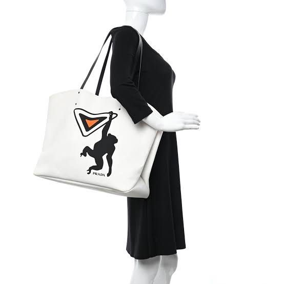 Prada White Canvas Tote Bag with Monkey Graphic (Category: Luxury Bags & Wallets) located in Tarlac. Submitted by jemserrano (Listing ID 1455563581, Image 2). Description: - Authentic Prada white canvas tote bag - Features a unique black monkey graphic on the iconic Prada triangle logo - Durable black leather handles - Ideal for everyday errands or weekend getaways Very good condition, need wash, missing inner pouch. Bag only no other inclusions.