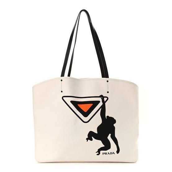 Prada White Canvas Tote Bag with Monkey Graphic (Category: Luxury Bags & Wallets) located in Tarlac. Submitted by jemserrano (Listing ID 1455563581, Image 1). Description: - Authentic Prada white canvas tote bag - Features a unique black monkey graphic on the iconic Prada triangle logo - Durable black leather handles - Ideal for everyday errands or weekend getaways Very good condition, need wash, missing inner pouch. Bag only no other inclusions.