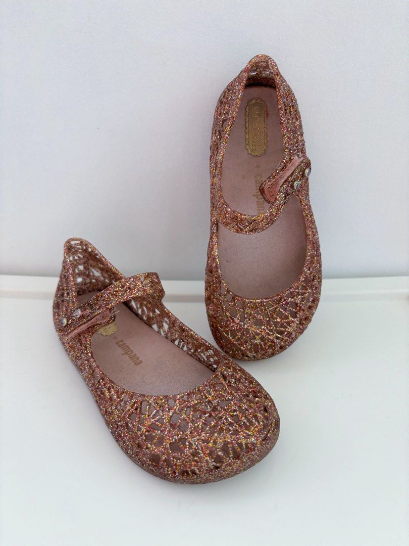 Preloved Bundle Mini Melissa Bundle US9 Jelly Shoes (Category: Babies & Kids Fashion) located in Marilao. Submitted by lmsboutique (Listing ID 1455582172, Image 2). Description: - Bundle of 2 pairs Mini Melissa jelly shoes - Pair 1: Dark glitter with black bows - Pair 2: Rose gold glitter with cutout design - Both are Mary Jane style with buckle straps - Perfect for little girls (Natatanggal na po yung black ribbon nung dollshoes dinikitan ko lan