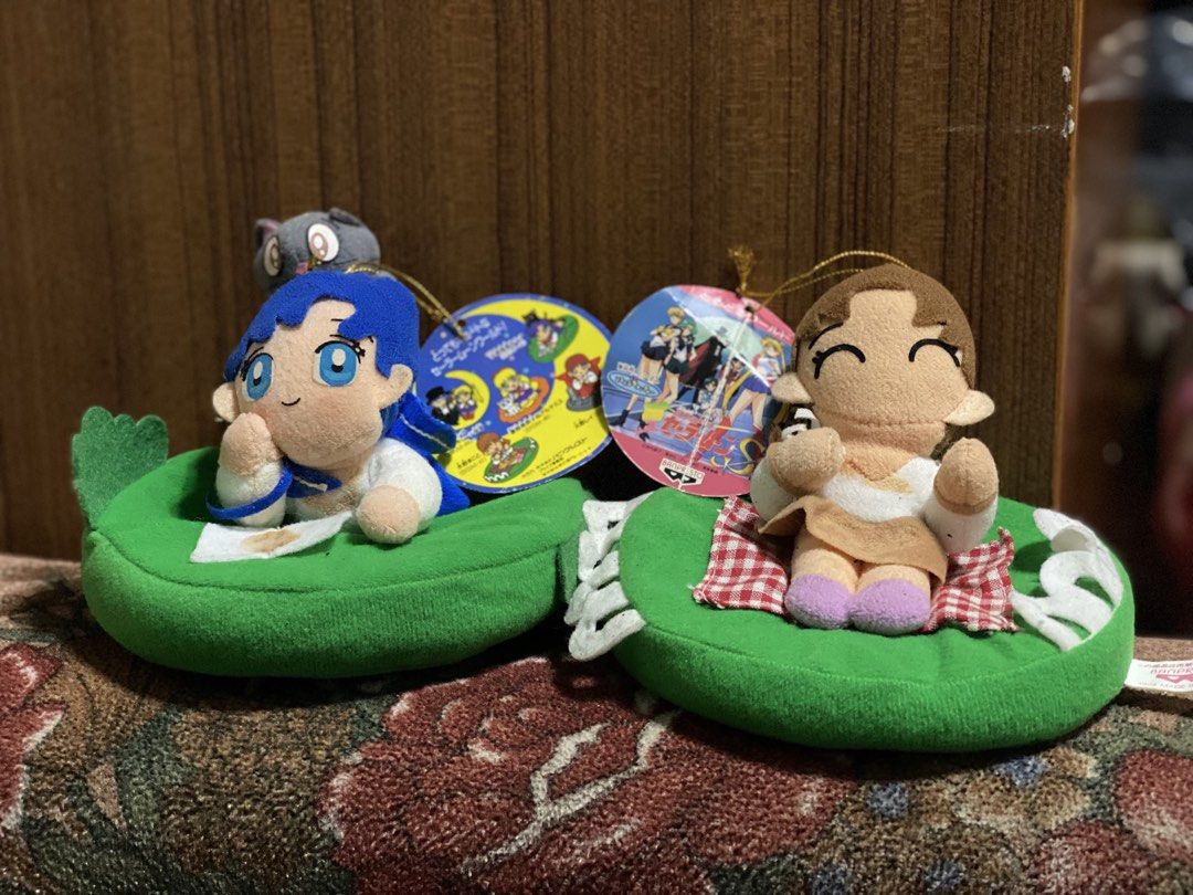 Sailor Moon Banpresto Plush Toys (Category: Plushies & Soft Toys) located in Manila. Submitted by kuya_moto (Listing ID 1455597645, Image 1). Description: - Two Sailor Moon plush toys from Banpresto. - Plush 1: Character with blue hair and a grey cat. - Plush 2: Character with brown hair. - Both plush toys are sitting on green, bean-shaped cushions. - Original tags are still attached..