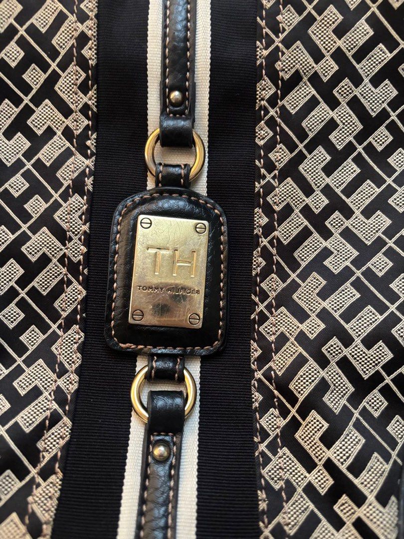 Tommy Hilfiger Monogram Shoulder Bag (Category: Luxury Bags & Wallets) located in Manila. Submitted by kzcat (Listing ID 1455527084, Image 3). Description: - Authentic Tommy Hilfiger shoulder bag - Classic TH monogram pattern in black and tan - Genuine leather trim and strap - Interior zippered pocket for essentials - Elegant gold hardware details - Iconic red Tommy Hilfiger interior tag It's been used! It has scratches on the front brand gold ha