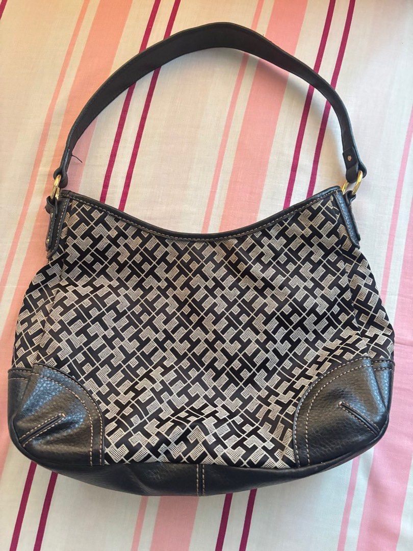 Tommy Hilfiger Monogram Shoulder Bag (Category: Luxury Bags & Wallets) located in Manila. Submitted by kzcat (Listing ID 1455527084, Image 2). Description: - Authentic Tommy Hilfiger shoulder bag - Classic TH monogram pattern in black and tan - Genuine leather trim and strap - Interior zippered pocket for essentials - Elegant gold hardware details - Iconic red Tommy Hilfiger interior tag It's been used! It has scratches on the front brand gold ha