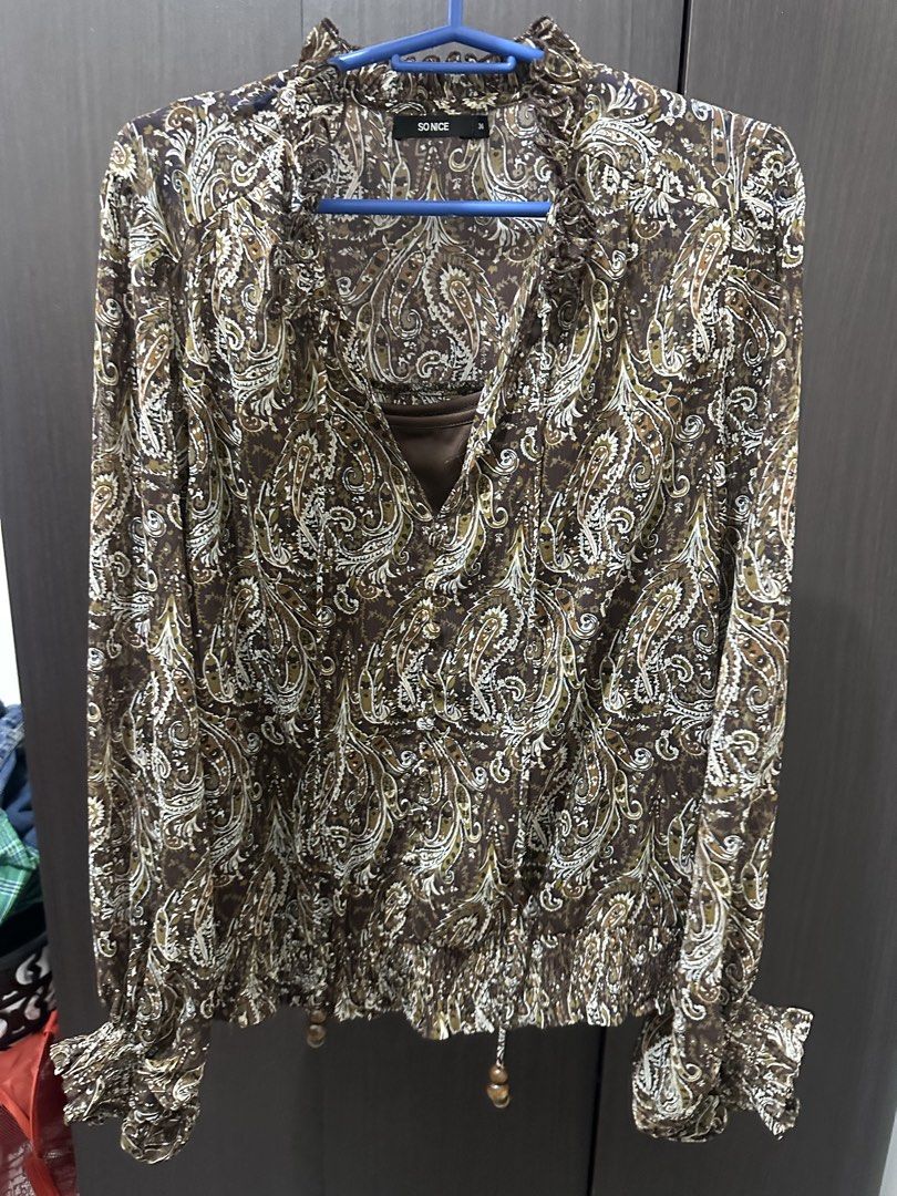 Brown Paisley Print Ruffle Neck Blouse (Category: Blouses) located in Angeles City. Submitted by frogstrology (Listing ID 1455815646, Image 1). Description: - Stylish brown blouse with a beautiful paisley print. - Elasticated hemline featuring charming decorative wooden beads. - Comfortable long sleeves Mod: jnt Mop: Gotyme.