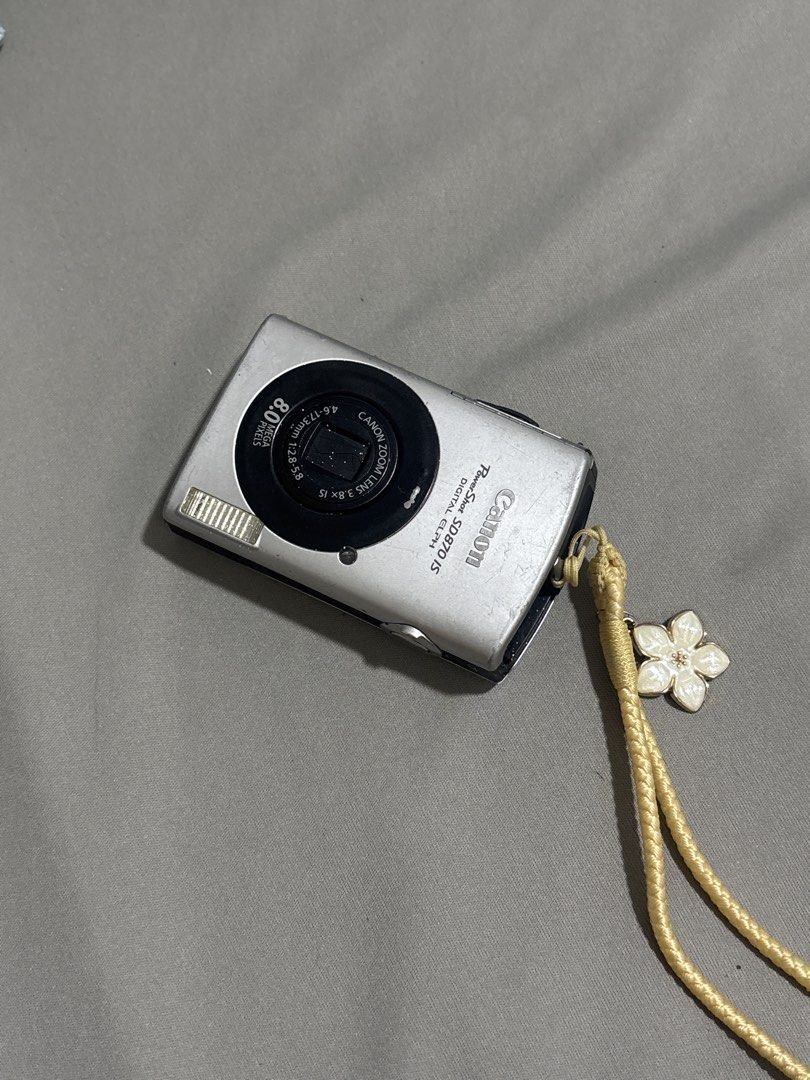 Canon PowerShot SD870 IS Digital Camera (Category: Cameras) located in Caloocan City. Submitted by theobnsacct (Listing ID 1455827129, Image 1). Description: - Canon PowerShot SD870 IS Digital Camera - 8.0 Megapixels for clear photos with a touch of nostalgia - 3.8x Optical Zoom to get closer - Comes with a cute flower charm strap, battery, charger, and case - Ideal for retro photography - Issue: screenburn and scratches - Ask me any questions or