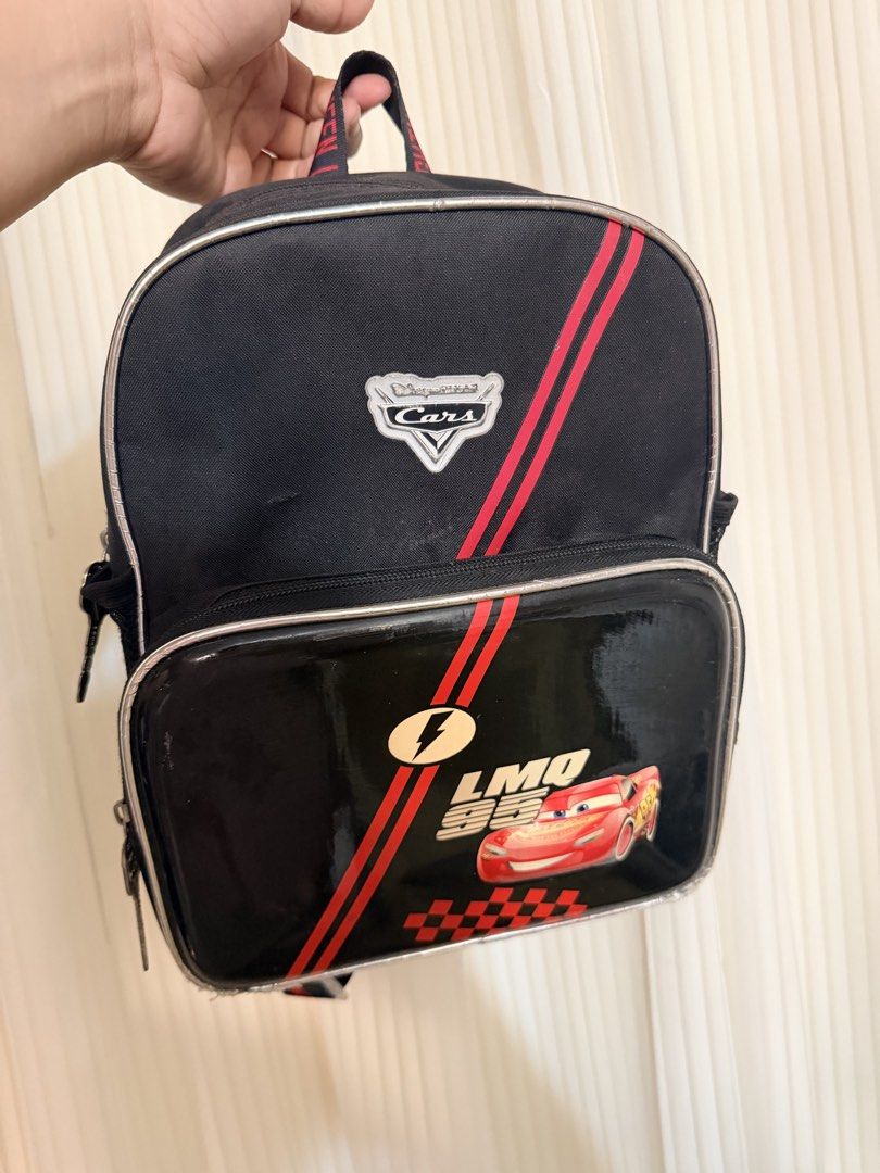 Take 2 | Disney Cars Lightning McQueen Black Backpack (Category: Babies & Kids Fashion) located in San Juan City. Submitted by thisismeely (Listing ID 1455853683, Image 1). Description: - Black backpack with awesome Lightning McQueen design - Features red stripes and checkered pattern on the front pocket - Straps are printed all over with 'Lightning McQueen' - Includes convenient mesh side pockets - Zippers have unique key-shaped pulls - Ideal fo