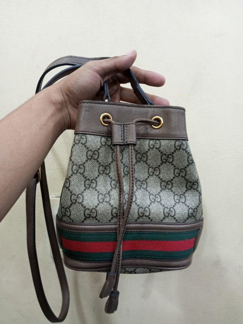 Gucci Monogram GG Supreme Canvas Bucket Bag (Category: Luxury Bags & Wallets) located in Bacolod City. Submitted by exequelgra46775 (Listing ID 1455762695, Image 1). Description: - Authentic Gucci bucket bag - Classic GG monogram canvas - Brown leather trim - Signature green and red stripe detail - Drawstring closure - Adjustable shoulder strap - Interior shows some signs of wear - Serial number visible in photos.