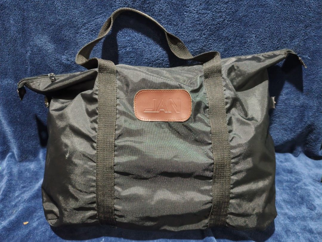 JAN Black Nylon Duffel Bag (Category: Luxury Bags & Wallets) located in Manila. Submitted by kirstentoyshub (Listing ID 1455827041, Image 1). Description: - JAN black nylon duffel bag - Two sturdy handles - Zippered closure - Brown leather patch with JAN logo on front - Ideal for weekend trips or gym sessions - Spacious interior.