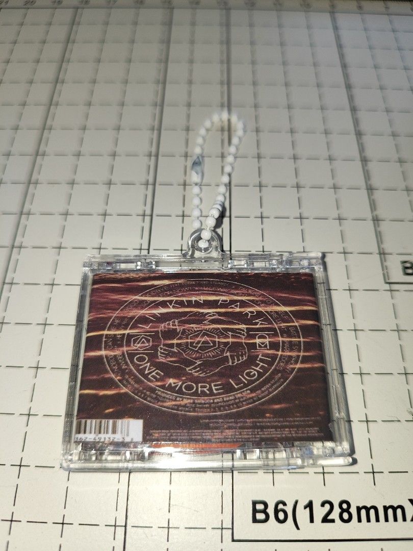 Linkin Park One More Light CD Keychain (Category: CDs & DVDs) located in Santo Domingo. Submitted by nfcminicdkeychainsbytin (Listing ID 1455851500, Image 3). Description: - Linkin Park 'One More Light' CD keychain - Features a stylish beaded strap - CD case opens up to reveal details - Tracklist shown in photos - Small and portable design - Ideal for Linkin Park fans.