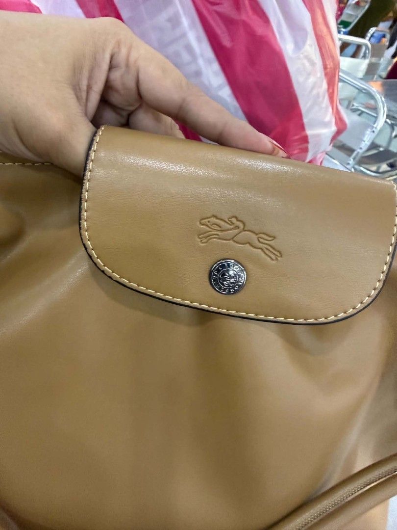 Longchamp Le Pliage Cuir Shoulder Bag (Category: Luxury Bags & Wallets) located in Antipolo. Submitted by robannrave98496 (Listing ID 1455809870, Image 3). Description: - Authentic Longchamp shoulder bag in tan leather - Versatile: Top handle and detachable shoulder strap - Secure flap closure with snap button - Made from soft and supple leather - Comes with a charming beaded accessory - Ideal for everyday use.
