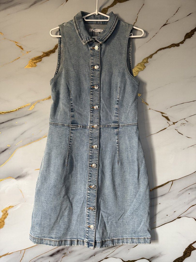 MANGO Denim Sleeveless Button-Up Dress (Category: Dresses) located in Marikina City. Submitted by declutter_keni24 (Listing ID 1455767589, Image 1). Description: - Light wash denim dress from MNG - Sleeveless design - Collared neckline - Full button-up front with silver-tone buttons - Fitted waist with a flared skirt - Versatile for casual or dressed-up occasions - Easy to style with sneakers or heels.