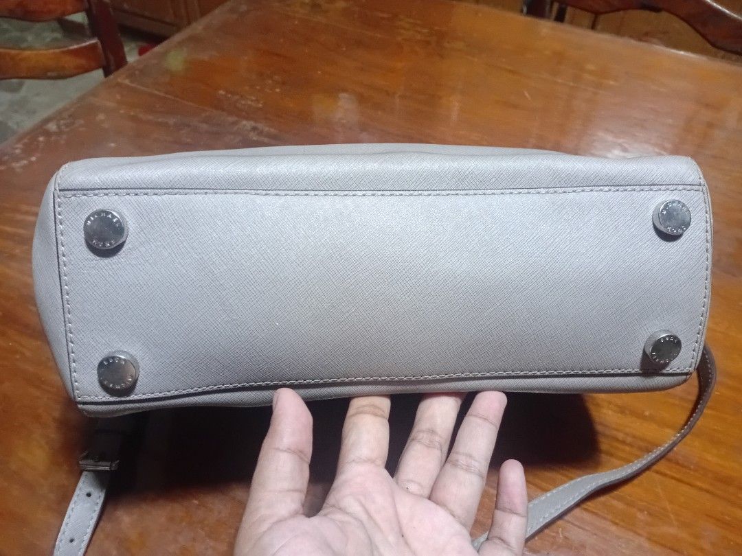 Michael Kors Grey Leather Satchel Handbag (Category: Luxury Bags & Wallets) located in San Pablo. Submitted by ronelomat32106 (Listing ID 1455708224, Image 3). Description: - Michael Kors grey leather satchel bag - Top handles and detachable shoulder strap - Secure zipper closure - Interior zip pocket and slip pockets - Protective metal feet on the bottom - Clean inside and out - Ideal for everyday use.