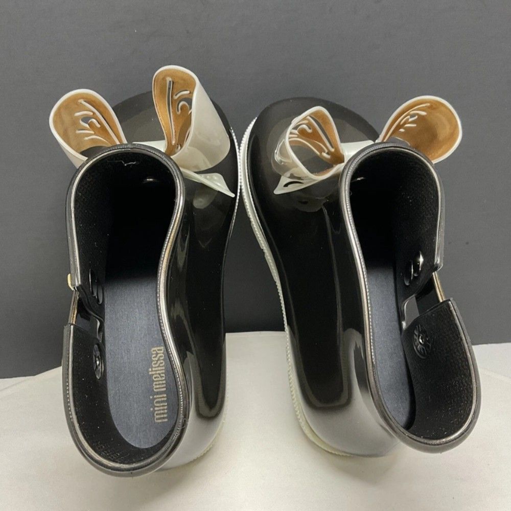 Mini Melissa Sugar Rain Bow Booties Black US7 (Category: Babies & Kids Fashion) located in Manila. Submitted by gigisimeon (Listing ID 1455769915, Image 2). Description: Mini Melissa Sugar Rain Bow Booties Black USA 7 *Used 2-3 x ONLY (church/mall) *with box -Cute Mini Melissa rain boots for kids. - Shiny dark brown/black color. - Features a pretty white and gold bow on the front. - Easy slip-on design. - Ideal for rainy days or outdoor play. - '
