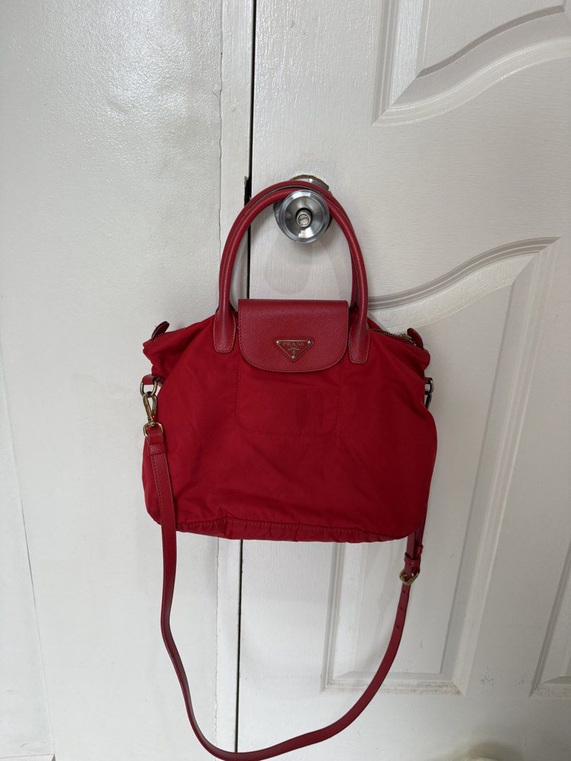 Prada Red Nylon Leather Trim Top Handle Bag (Category: Luxury Bags & Wallets) located in Muntinlupa City. Submitted by joycups (Listing ID 1455811459, Image 1). Description: - Authentic Red Prada Bag - Durable Nylon Body with Leather Trim - Comfortable Leather Handles - Detachable Shoulder Strap for Versatility - Secure Zipper Closure on Top - Convenient Front Flap Pocket with Magnetic Snap - Elegant Gold Hardware Details - Ideal Everyday Bag.