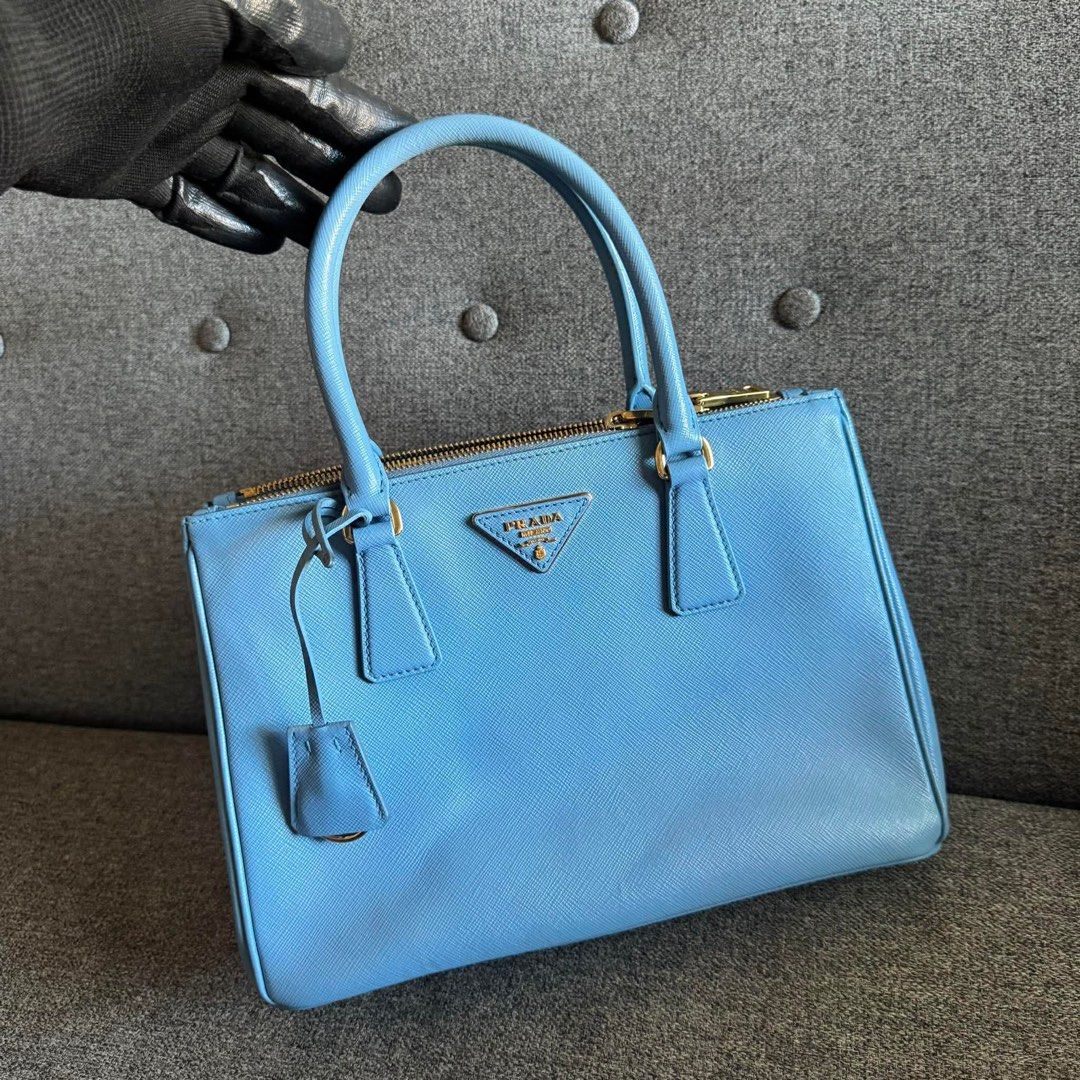 Prada Saffiano Lux Tote Bag Light Blue (Category: Luxury Bags & Wallets) located in Madrid. Submitted by jhunaceee (Listing ID 1455815258, Image 2). Description: - Authentic Prada Saffiano Lux Tote - Beautiful Light Blue Color - Elegant Gold Hardware Details - Includes Original Dust Bag - Perfect for Everyday or Special Occasions - Ample Interior Space - Secure Top Zip Closure - Comfortable Double Top Handles - A Timeless Prada Classic.