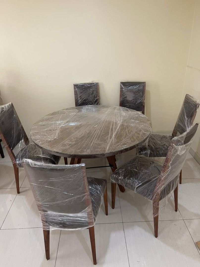 Round Wooden Dining Table (6 Seater) (Category: Tables & Sets) located in Manila. Submitted by cheap.escape (Listing ID 1455821578, Image 1). Description: Round Wooden Dining Table - Includes 6 matching chairs with dark upholstered seats - Hard wood. Brand New! Still covered. Price negotiable for sure buyer! - Originally bought for P64k, selling for 50k! RFS: Hindi bagay sa bahay and ayaw din nila ng wood-finish 😅.