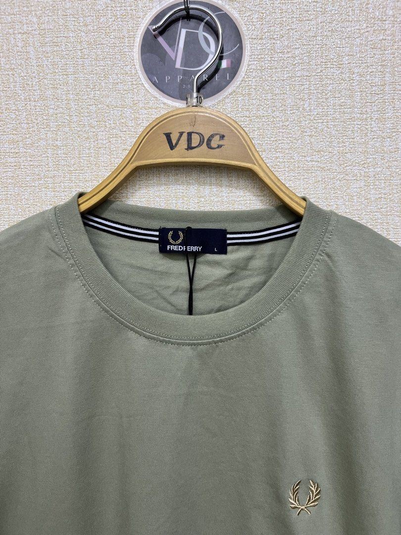 Sage Green Fred Perry crew neck t-shirt (Category: Luxury Apparel) located in Imus. Submitted by vdc.apparel (Listing ID 1455772434, Image 3). Description: This sage green Fred Perry crew neck t-shirt features a subtle embroidered gold laurel wreath logo on the chest and striped neck tape detailing..