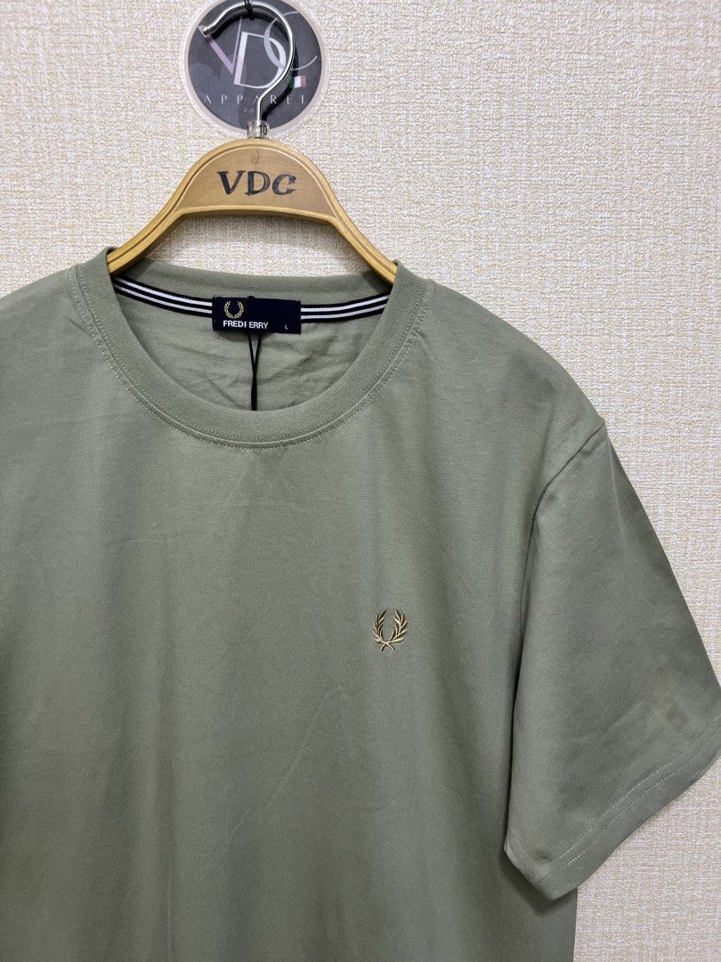 Sage Green Fred Perry crew neck t-shirt (Category: Luxury Apparel) located in Imus. Submitted by vdc.apparel (Listing ID 1455772434, Image 2). Description: This sage green Fred Perry crew neck t-shirt features a subtle embroidered gold laurel wreath logo on the chest and striped neck tape detailing..