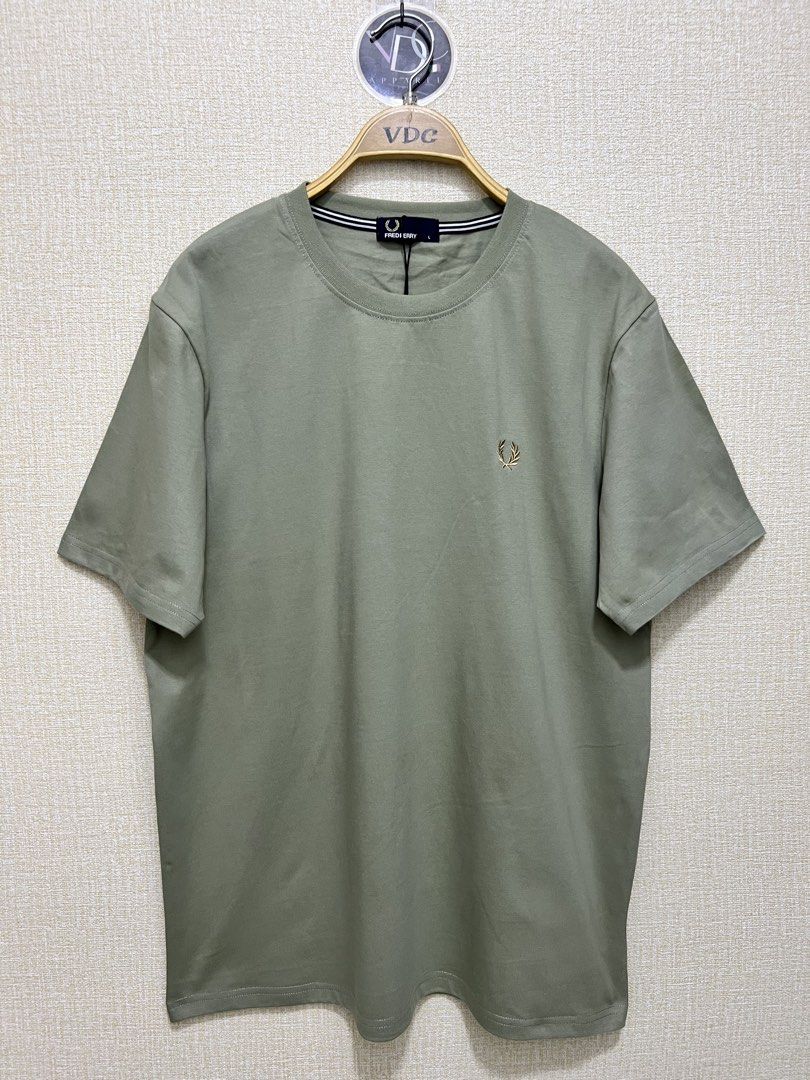 Sage Green Fred Perry crew neck t-shirt (Category: Luxury Apparel) located in Imus. Submitted by vdc.apparel (Listing ID 1455772434, Image 1). Description: This sage green Fred Perry crew neck t-shirt features a subtle embroidered gold laurel wreath logo on the chest and striped neck tape detailing..