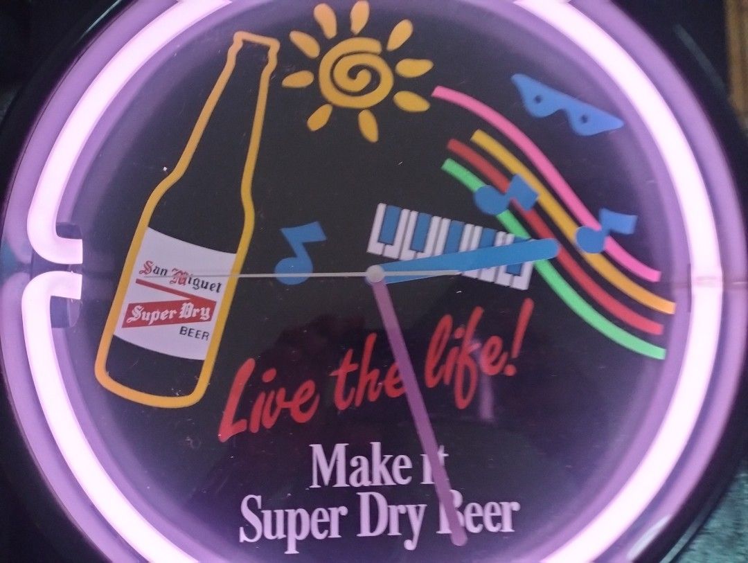 San Miguel Super Dry Beer Neon Clock (Category: Clocks) located in Cainta. Submitted by vacg0630 (Listing ID 1455788323, Image 1). Description: - Vintage San Miguel Super Dry Beer neon clock - Vibrant pink neon light - Unique design featuring a beer bottle, sun, piano keys, and musical notes - Text includes 'Live the life!' and 'Make it Super Dry Beer' - Powered by reliable quartz movement Clock not WORKING 4800 Shipping not ncluded QR code/Bank 