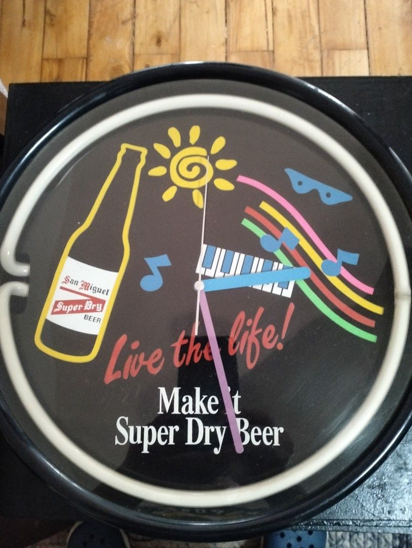San Miguel Super Dry Beer Neon Clock (Category: Clocks) located in Cainta. Submitted by vacg0630 (Listing ID 1455788323, Image 2). Description: - Vintage San Miguel Super Dry Beer neon clock - Vibrant pink neon light - Unique design featuring a beer bottle, sun, piano keys, and musical notes - Text includes 'Live the life!' and 'Make it Super Dry Beer' - Powered by reliable quartz movement Clock not WORKING 4800 Shipping not ncluded QR code/Bank 