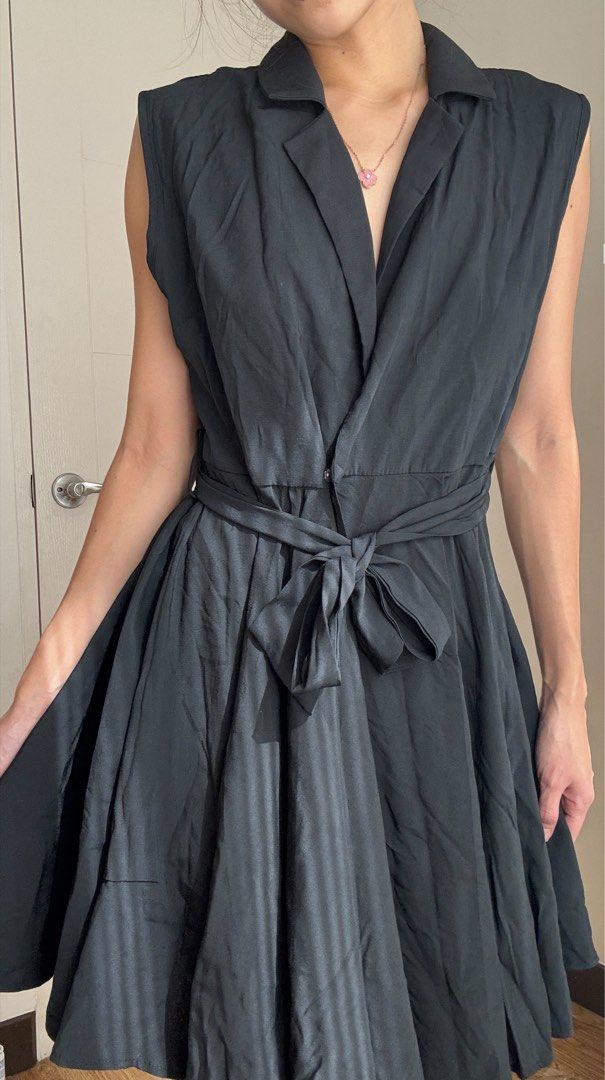 Sleeveless Black Collared Wrap Dress with Belt (Category: Dresses) located in Mandaluyong City. Submitted by anj_declutters (Listing ID 1455744012, Image 3). Description: - Sleeveless black dress - Collared neckline - Wrap front design - Includes matching fabric belt - Flared, pleated skirt - Ideal for smart casual or work occasions - Versatile for dressing up or down.