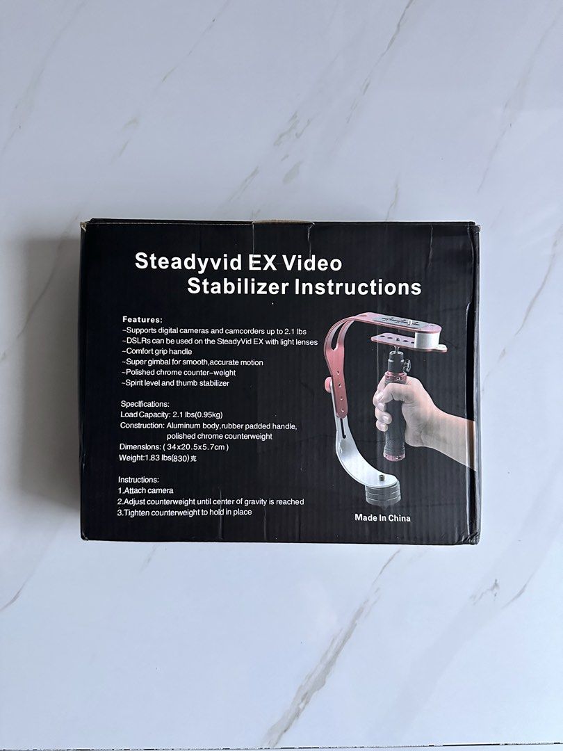 Steadyvid EX Video Stabilizer (Category: Gimbals & Stabilizers ) located in Paranaque City. Submitted by daenydaeny (Listing ID 1455768245, Image 1). Description: - Steadyvid EX Video Stabilizer - Supports DSLRs and camcorders up to 2.1 lbs - Lightweight aluminum body (1.83 lbs) - Padded handle with comfort grip - Finished counter-weight for smooth motion - Includes spirit level and thumb stabilizer.