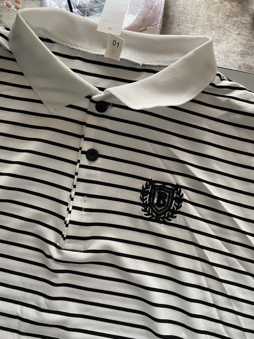 Striped Polo Shirt with Emblem (Category: Tshirts & Polo Shirts ) located in Taguig. Submitted by msifycart (Listing ID 1455720480, Image 3). Description: - Classic black and white striped polo shirt - Short sleeves - Button-up neckline - Small emblem on the chest - Contrasting collar and cuffs - Ideal for a smart casual look.