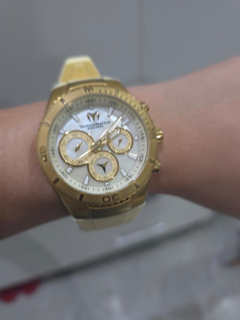 TechnoMarine Gold Chronograph Watch Cream Strap (Category: Women's Watches) located in Davao. Submitted by hunnyledesma1230 (Listing ID 1455724031, Image 1). Description: - Brand: TechnoMarine - Color: Gold with cream silicone strap - Dial: Mother of pearl with gold accents - Features: Chronograph, three subdials, rotating bezel - Condition: Comes with original box - Style: Versatile for everyday or special occasions.