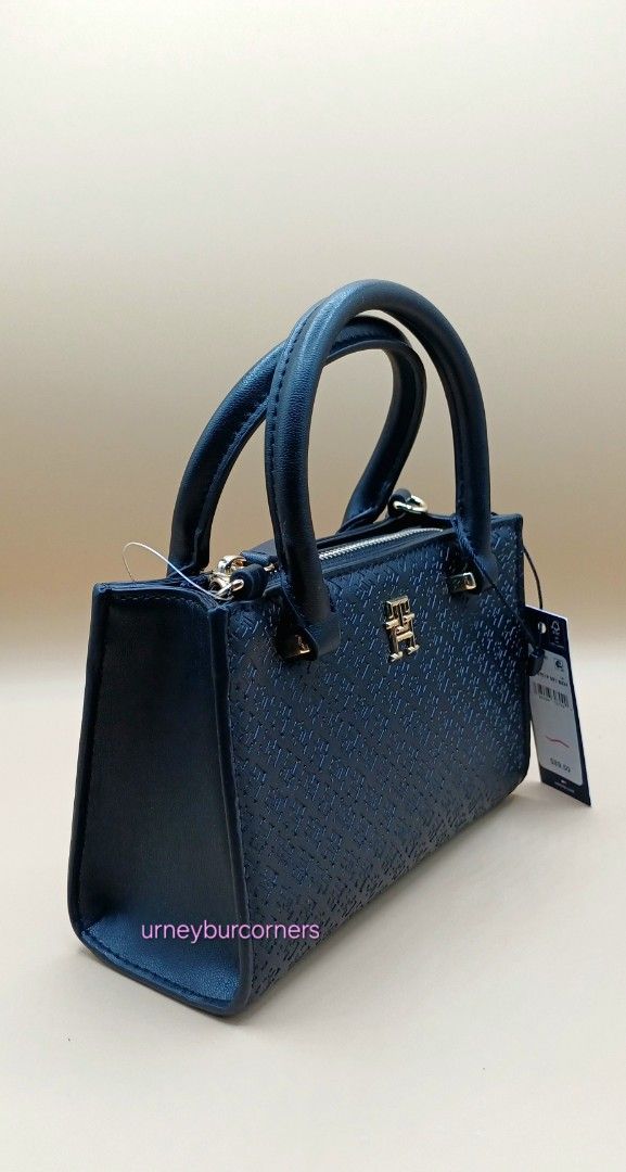 Tommy Hilfiger Black Monogram Mini Top Handle Bag (Category: Luxury Bags & Wallets) located in Imus. Submitted by urneyburcorners (Listing ID 1455678210, Image 2). Description: - Authentic Tommy Hilfiger mini top handle bag - Features iconic TH monogram embossed pattern - Elegant gold hardware details - Includes both top handles and a detachable shoulder strap - Comes with original tags attached - Versatile for both everyday use and evening outin
