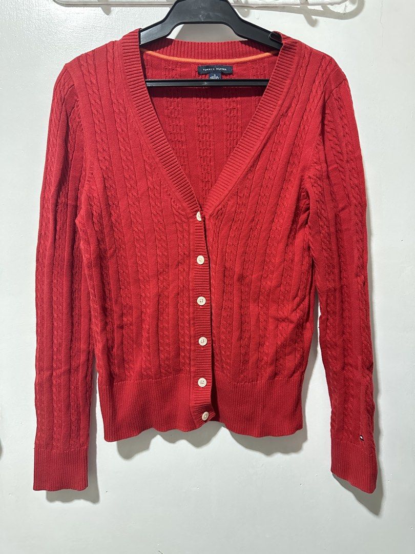 Tommy Hilfiger Red Cable Knit Button Up Cardigan (Category: Coats, Jackets and Outerwear) located in Calamba. Submitted by berngundy (Listing ID 1455767246, Image 1). Description: - Classic red Tommy Hilfiger cable knit cardigan - V-neckline - Button-up front with embossed Tommy Hilfiger logo buttons - Versatile for layering over tops or dresses - Comfortable and stylish.