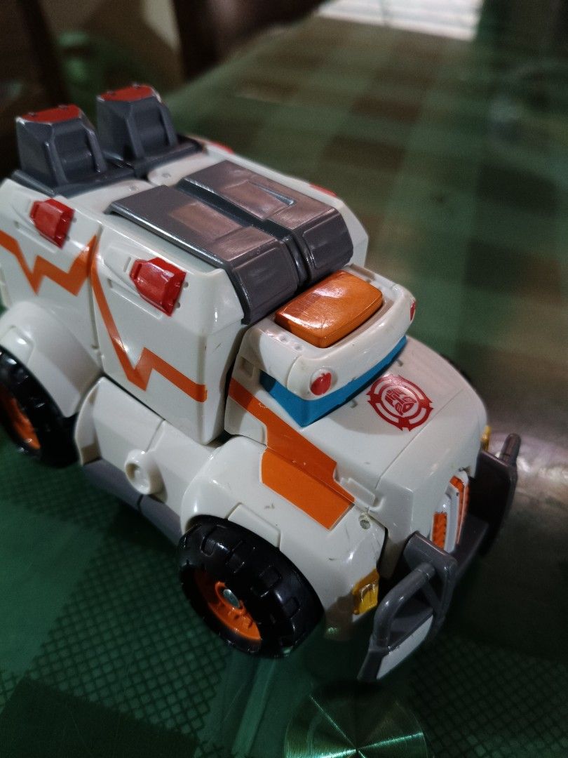 Transformers Rescue Bots Ambulance Toy (Category: Action & Battle Toys) located in Angeles City. Submitted by mysticdeer-32c4 (Listing ID 1455729360, Image 3). Description: - Transforming Rescue Bots toy - Converts from ambulance to robot - Features Autobot logo on chest and side - Classic orange and white color scheme - Ideal for fans of the Transformers Rescue Bots show rare transformer.