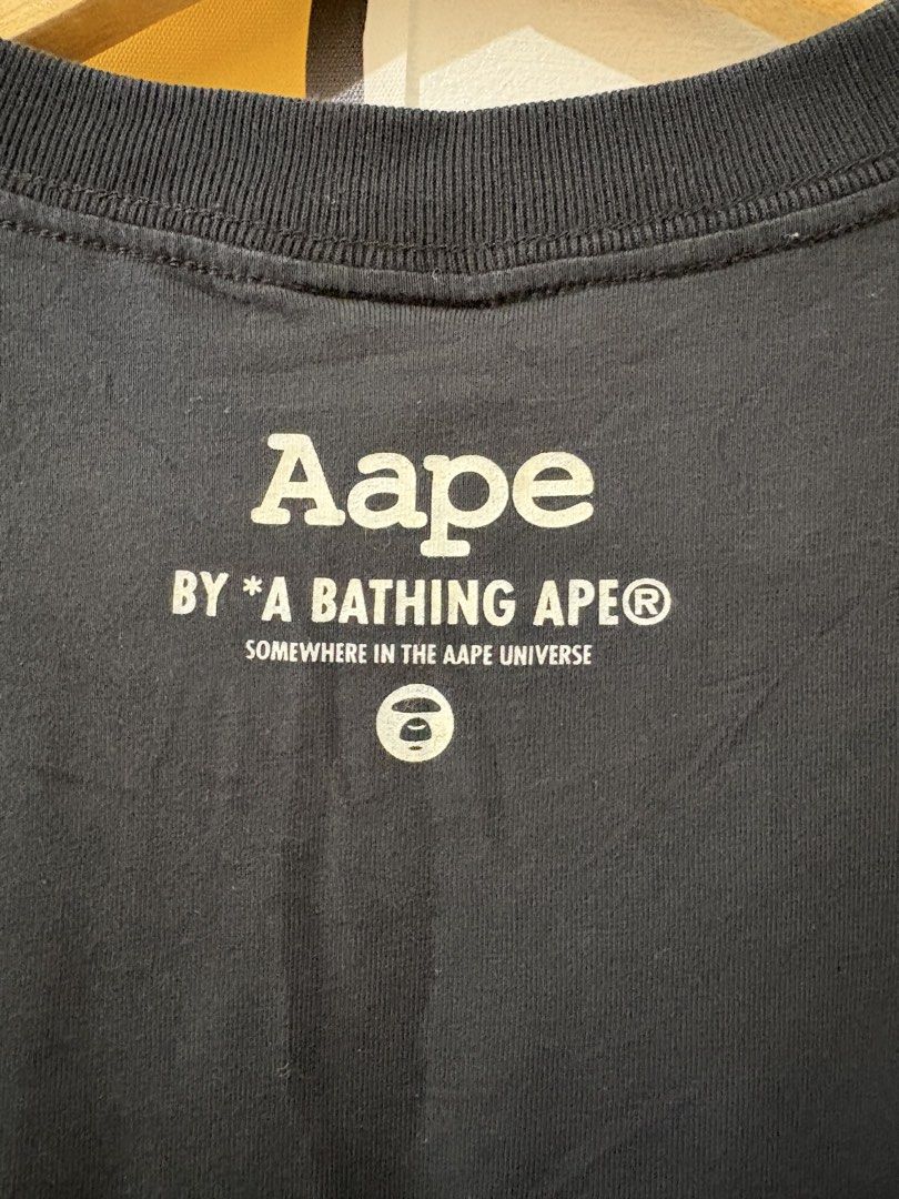 Aape (Category: Tshirts & Polo Shirts ) located in Echague. Submitted by jake_rc (Listing ID 1455991030, Image 3). Description: AAPE by A Bathing Ape Big Head T-Shirt in black, featuring a pink camouflage-filled logo on the chest and a matching logo near the hem. Size XS on tag Dimes 19.5 x 32 (medyo mahaba length) No cracks on print Color 9.3/10 Price 750 plus SF.