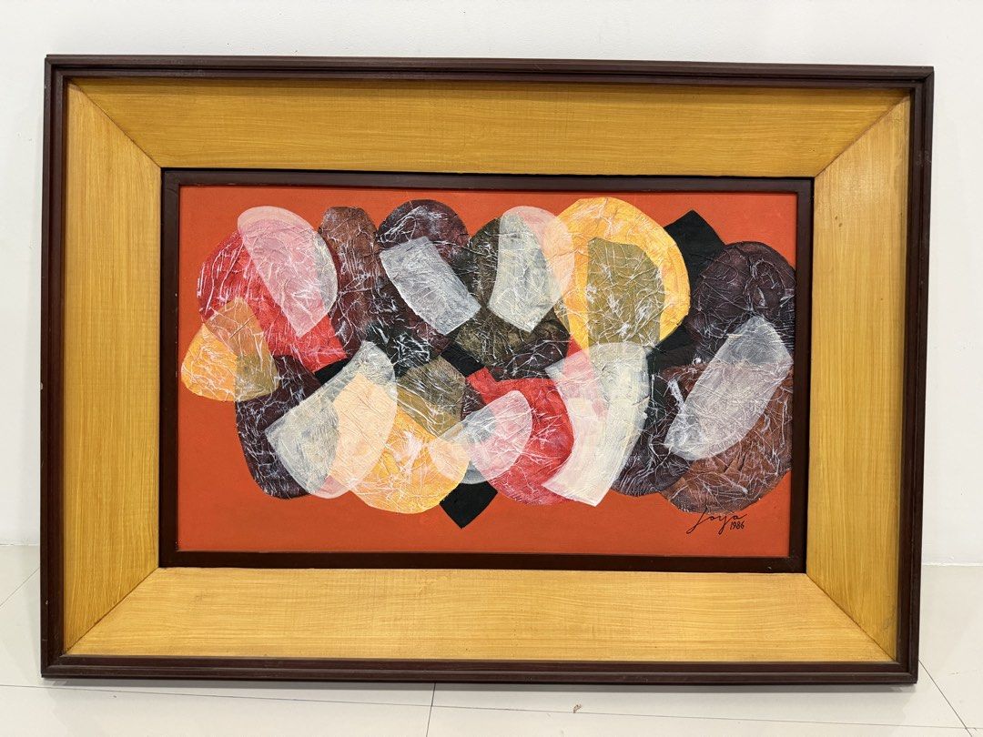 Abstract Painting by Joya, 1986 (Category: Art & Prints) located in Manila. Submitted by blue_valdez (Listing ID 1455994656, Image 1). Description: Joya Size: 18x30 Oil on canvas With COA - Framed abstract artwork by Joya, signed 1986. - Features a vibrant orange background with layered shapes in red, white, yellow, brown, and black. - Elegant frame with a dark brown outer edge and a golden wood inner frame. - Perfect for adding a pop of color to