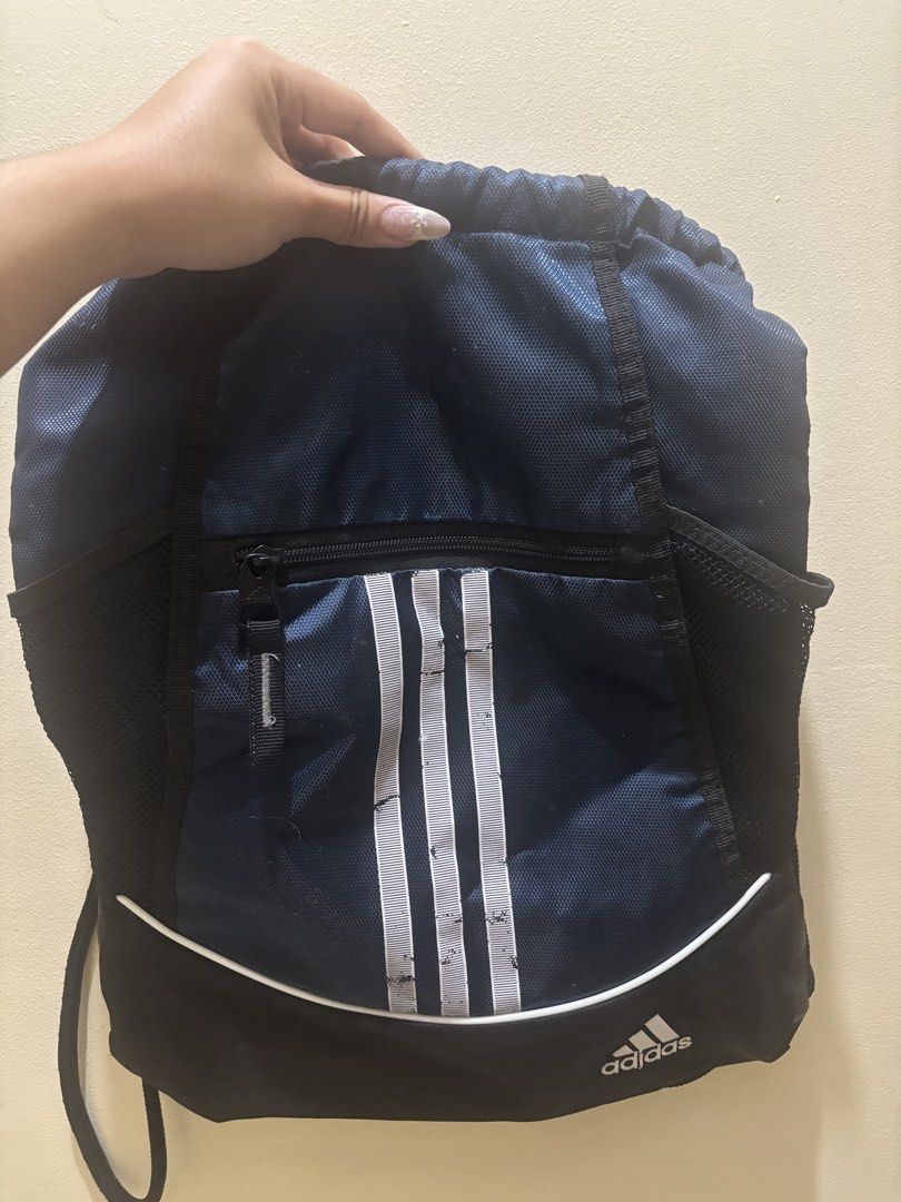 Adidas Drawstring Bag Navy Blue (Category: Backpacks) located in Manila. Submitted by karinaaaaaaa2000 (Listing ID 1456001756, Image 1). Description: - Navy blue Adidas drawstring bag - Front zip pocket - Mesh side pockets - Black base - Adidas logo and three stripes on front - Drawstring closure - Ideal for gym or sports loc: marikina mop: gcash/bank transfer mod: j&t express or lalamove.