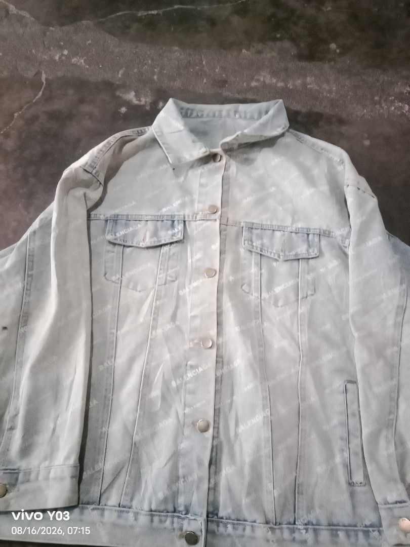 Balenciaga All Over Logo Denim Jacket (Category: Coats, Jackets and Outerwear) located in Cabuyao City. Submitted by blake657 (Listing ID 1455855070, Image 1). Description: - Light wash denim jacket - All-over Balenciaga logo print - Classic trucker style - Button front closure - Two front flap chest pockets - Button cuffs - Oversized fit, likely fits Medium to Large - Bold statement piece for any outfit no tag's po sya.