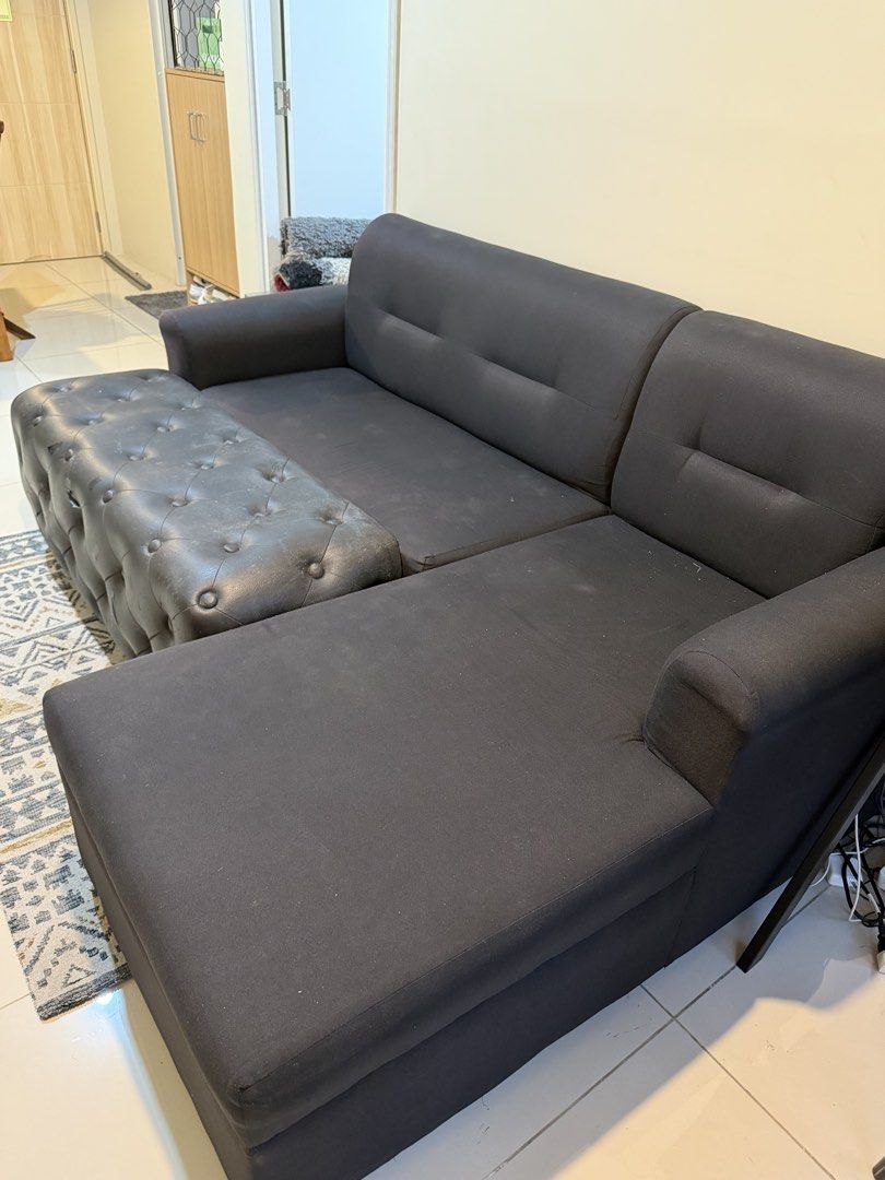 Black L-Shaped Sofa with Ottoman (Category: Sofas) located in Manila. Submitted by pathealy (Listing ID 1455900270, Image 2). Description: - Black L-shaped sofa - Includes a tufted ottoman (can be used as a footrest or extra seating) - Ottoman has some wear and tear on the edges - Comfortable and spacious design - Ideal for living rooms - Pickup only.