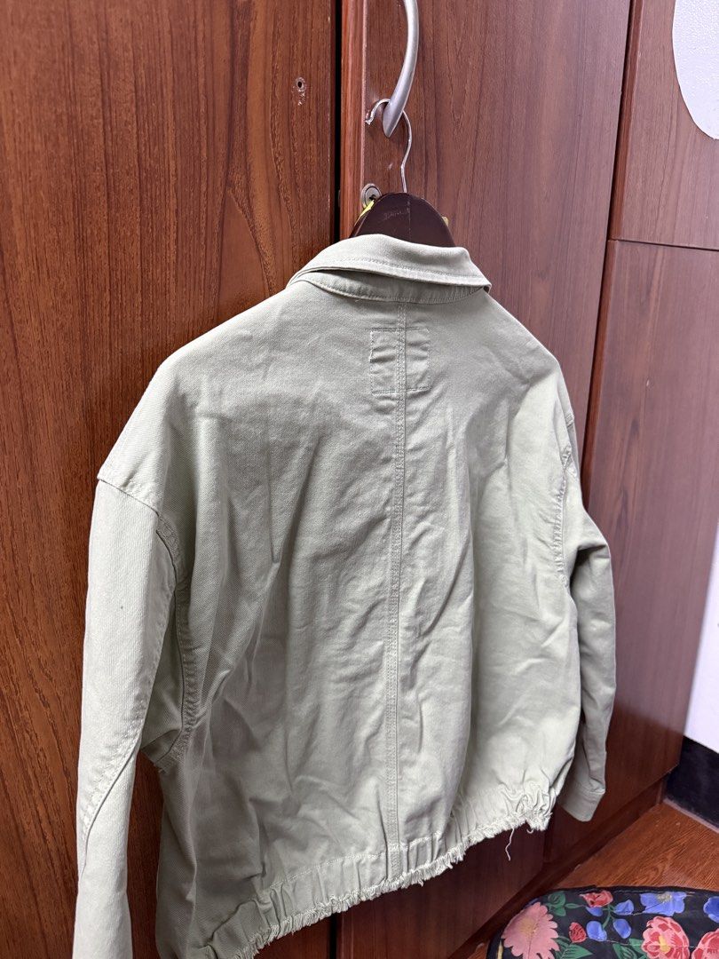 Bossini Jeans Sage Green Type 2 Denim Jacket (Category: Coats, Jackets and Outerwear) located in Cavite. Submitted by g1mon (Listing ID 1455989800, Image 2). Description: This item is preloved (not thrifted) (barely used) Tagged size: Large Measurements (inches): Pit-to-pit: 20.5 Length: 21 Issues: None *Note: Lighting may affect the colour in the image* - Sage green denim jacket from Bossini Jeans - Size L - Two chest pockets - Frayed hem detail