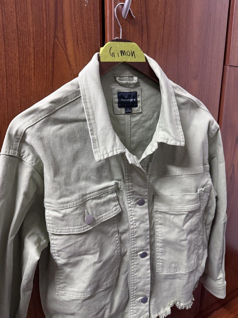 Bossini Jeans Sage Green Type 2 Denim Jacket (Category: Coats, Jackets and Outerwear) located in Cavite. Submitted by g1mon (Listing ID 1455989800, Image 1). Description: This item is preloved (not thrifted) (barely used) Tagged size: Large Measurements (inches): Pit-to-pit: 20.5 Length: 21 Issues: None *Note: Lighting may affect the colour in the image* - Sage green denim jacket from Bossini Jeans - Size L - Two chest pockets - Frayed hem detail