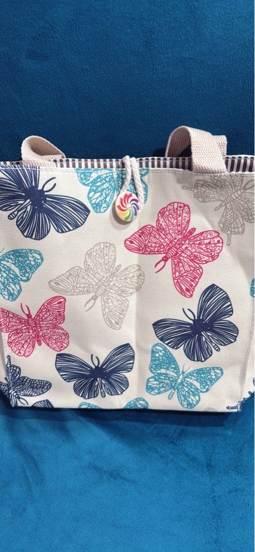 Butterfly Print Canvas Tote Bag (Category: Tote Bags) located in Quezon City. Submitted by stuffamania (Listing ID 1455907346, Image 2). Description: - Adorable canvas tote bag with a charming butterfly print. - Features a brown and white striped interior. - Includes a few small pockets inside for organization. - Beige canvas handles for comfortable carrying. - Ideal for your lunch, snacks, or other small daily essentials. - Easy to clean and mai
