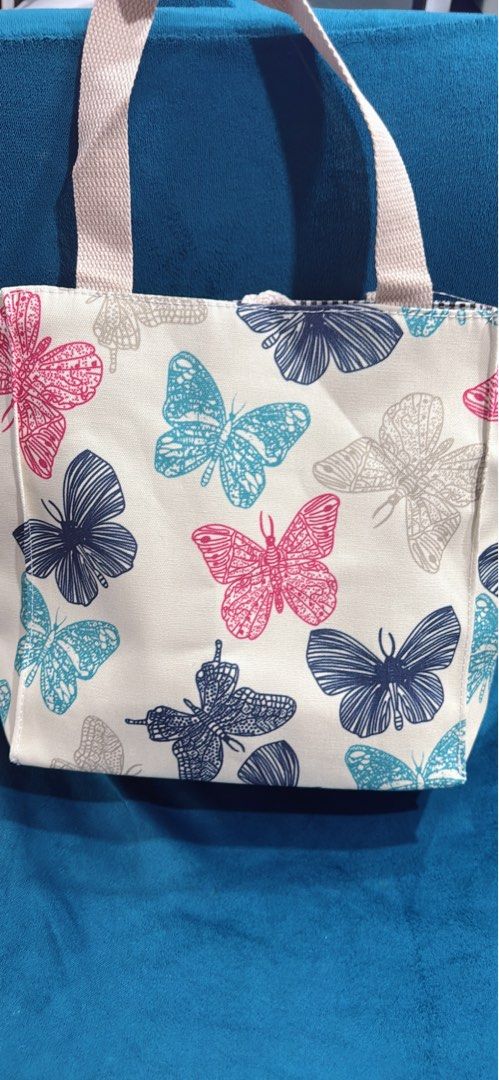 Butterfly Print Canvas Tote Bag (Category: Tote Bags) located in Quezon City. Submitted by stuffamania (Listing ID 1455907346, Image 3). Description: - Adorable canvas tote bag with a charming butterfly print. - Features a brown and white striped interior. - Includes a few small pockets inside for organization. - Beige canvas handles for comfortable carrying. - Ideal for your lunch, snacks, or other small daily essentials. - Easy to clean and mai