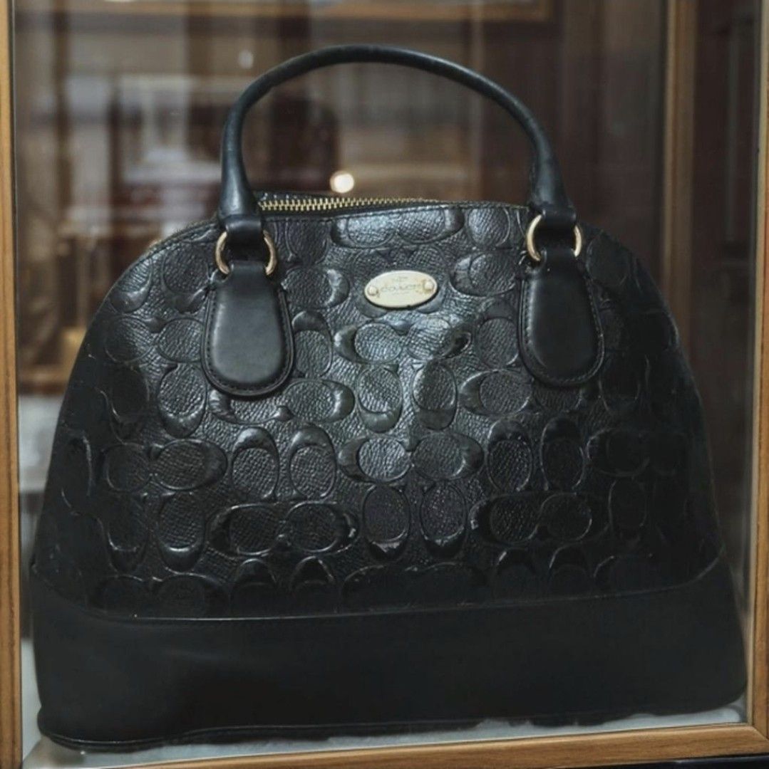 Coach Alma (Category: Luxury Bags & Wallets) located in Manila. Submitted by bellissima05 (Listing ID 1455959570, Image 1). Description: Description: Structured Coach satchel in black embossed leather. Signature 'C' pattern across the body. Gold-tone hardware and chain accents. Top handles and a detachable strap for versatility. Sleek, polished look for everyday or special occasions..