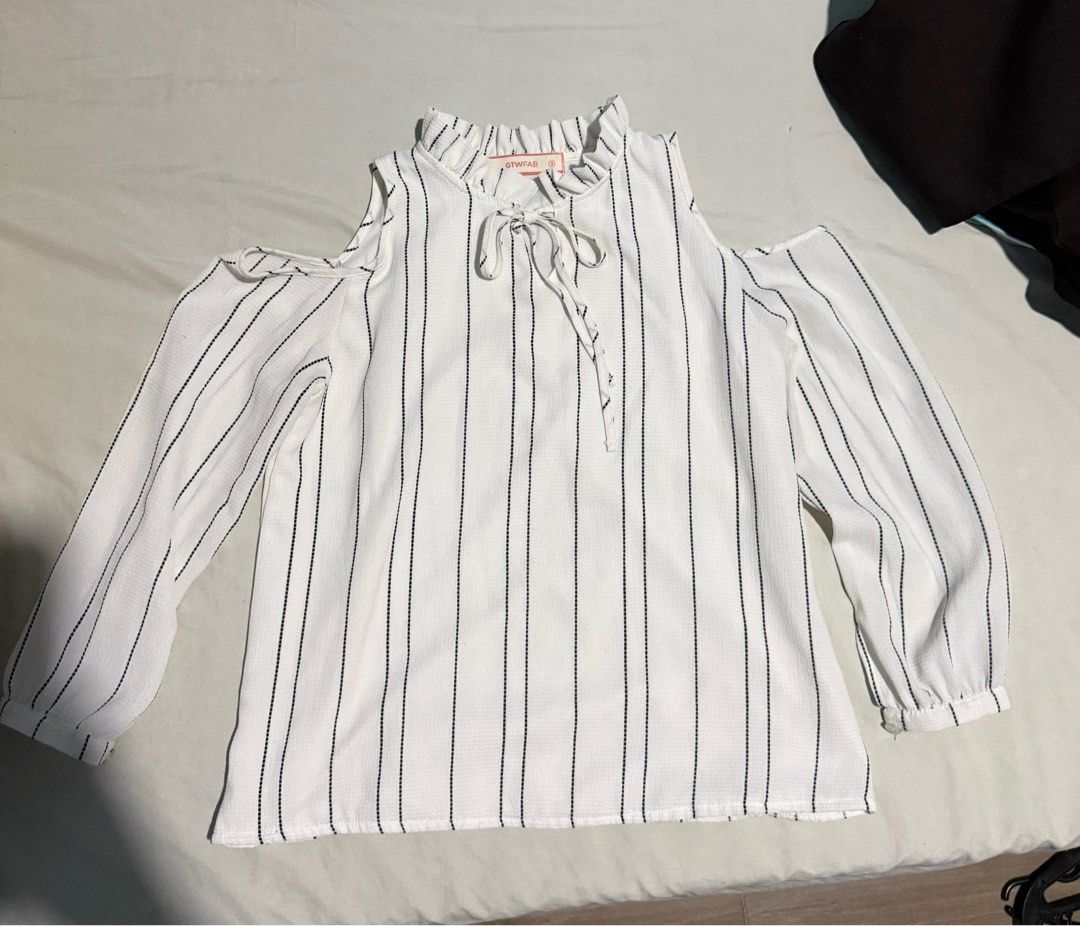 Cold Shoulder Ruffle Neck Top Size S (Category: Blouses) located in Santa Rosa. Submitted by micstuff (Listing ID 1456010492, Image 2). Description: - White top with black vertical stripes - Cold shoulder design - Long sleeves - Ruffle detail around the neckline - Tie-up front - Brand: GTWFAB - Size: S - Versatile for casual outings or dressing up.