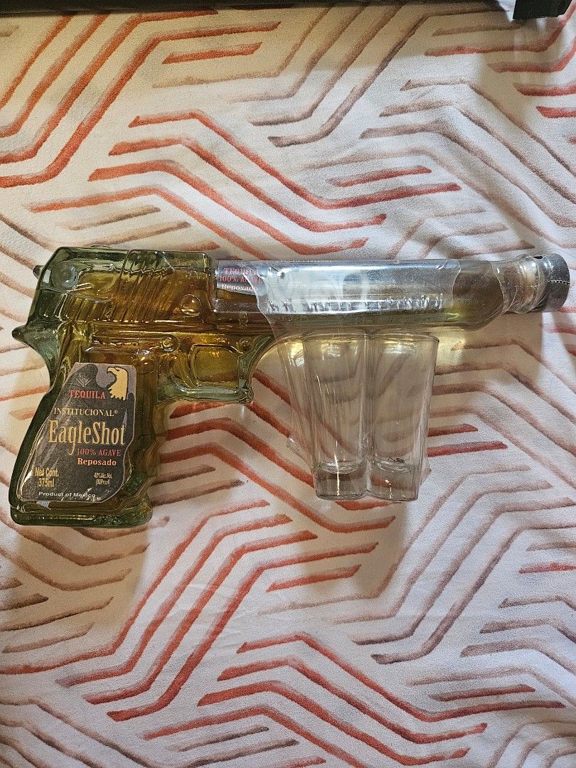 Eagle Shot Tequila Bottle with Shot Glasses (Category: Water Bottles & Tumblers) located in Manila. Submitted by gcprime (Listing ID 1456050160, Image 1). Description: - Unique Eagle Shot tequila bottle - Shaped like a gun - Includes two attached shot glasses - Bottle is unopen - Perfect for collectors, bar displays, or as a novelty gift still negotiable.