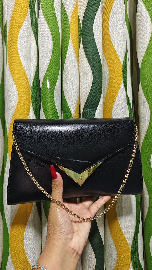 Givenchy Moon Cut Out Leather Handbag (Category: Luxury Bags & Wallets) located in Tambulig. Submitted by cmscloset_ph (Listing ID 1455985938, Image 2). Description: - Vintage Givenchy black leather handbag - Features a gold-tone 'moon' cut-out detail on the flap - Delicate gold chain strap - Made in Japan - Perfect for evenings or adding a classic touch - Minor signs of wear on leather, consistent with age.