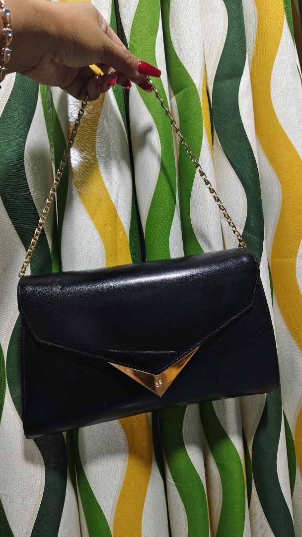 Givenchy Moon Cut Out Leather Handbag (Category: Luxury Bags & Wallets) located in Tambulig. Submitted by cmscloset_ph (Listing ID 1455985938, Image 3). Description: - Vintage Givenchy black leather handbag - Features a gold-tone 'moon' cut-out detail on the flap - Delicate gold chain strap - Made in Japan - Perfect for evenings or adding a classic touch - Minor signs of wear on leather, consistent with age.